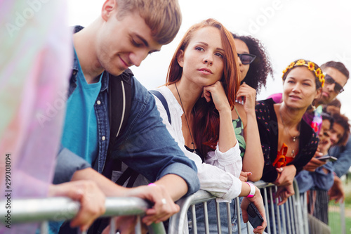 Group Of Young Friends Waiting Behind Barrier At Entrance To Music Festival Site © Monkey Business