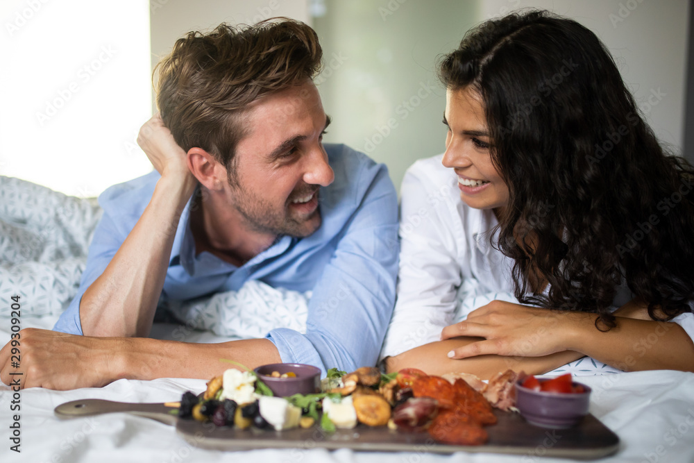 Happy young couple eat breakfast in bed in morning Happy young couple eat breakfast in bed in morning