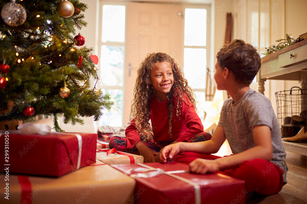 Excited Children Opening Presents By Tree On Christmas Morning - obrazy, fototapety, plakaty 