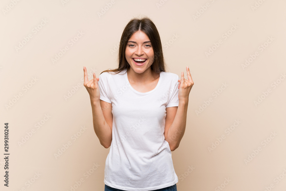 Pretty young girl over isolated background making rock gesture Pretty young girl over isolated background making rock gesture
