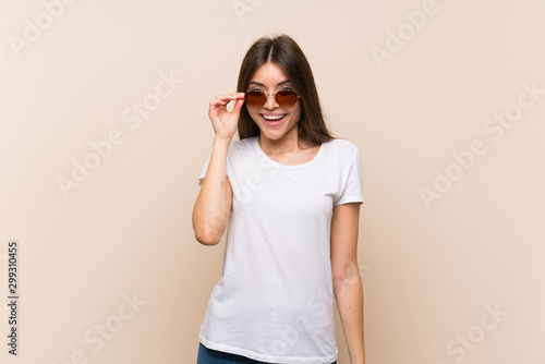 Pretty young girl over isolated background with glasses and happy