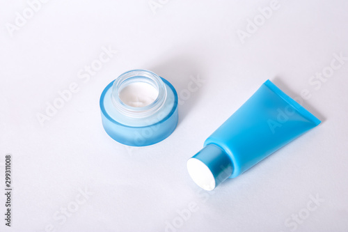 tube with moisturizing mask blue and a jar of cream blue on a white background