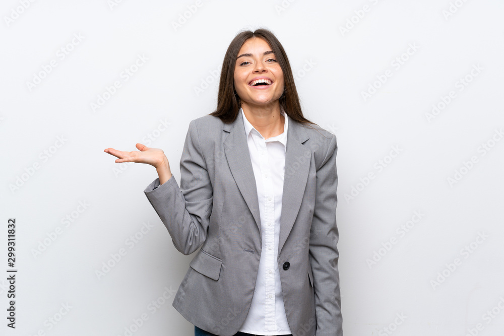 Young business woman over isolated white background holding copyspace imaginary on the palm to insert an ad Young business woman over isolated white background holding copyspace imaginary on the palm to insert an ad