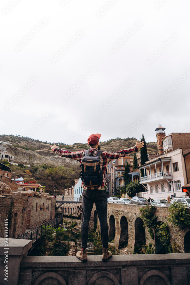 01.06.2019 Tbilisi, Georgia: photo of stylish bearded tourist strolling through the streets of Tbilisi's old city, posing for photos, taking photos and talking with people