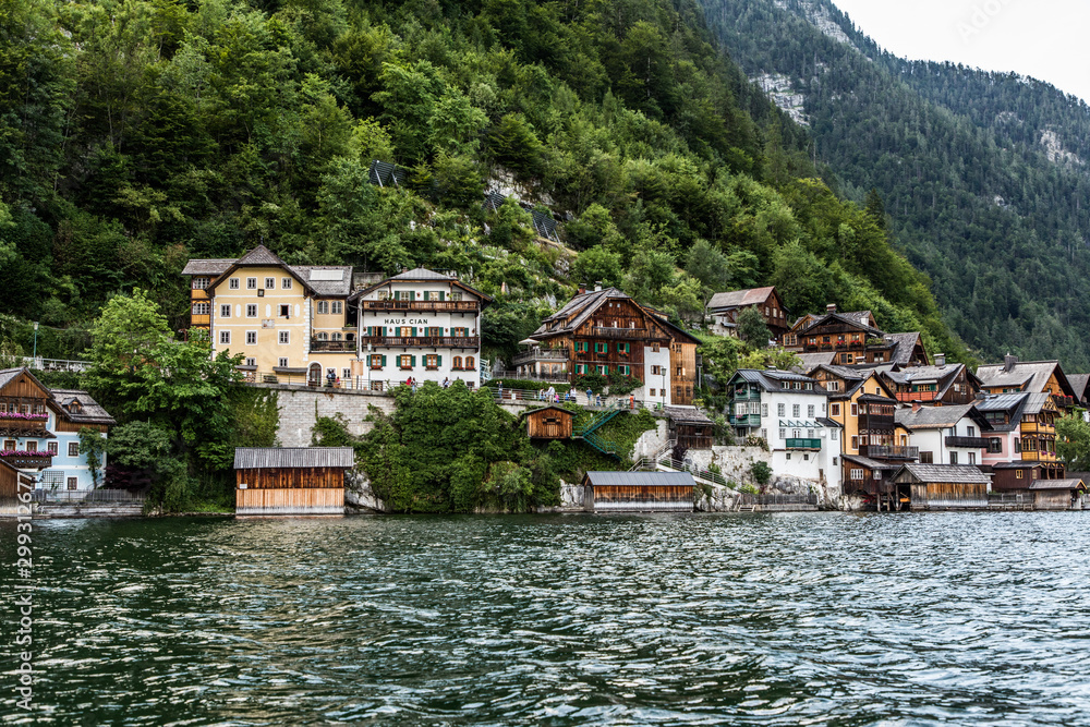 Fototapeta premium Hallstadt, Austria - July 2019: Picturesque old small town Hallstadt is Austrian state of Upper Austria, beautiful place surrounded by Alp mountains and amazing lake Dachstein with village reflections