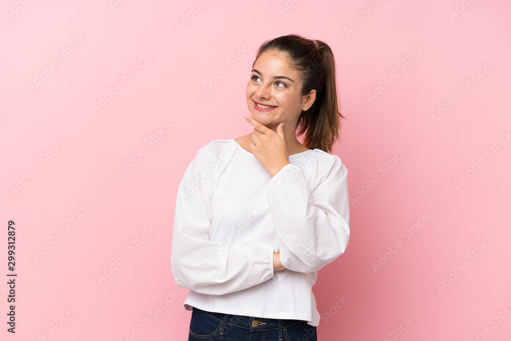 Young brunette girl over isolated pink background looking to the side Young brunette girl over isolated pink background looking to the side
