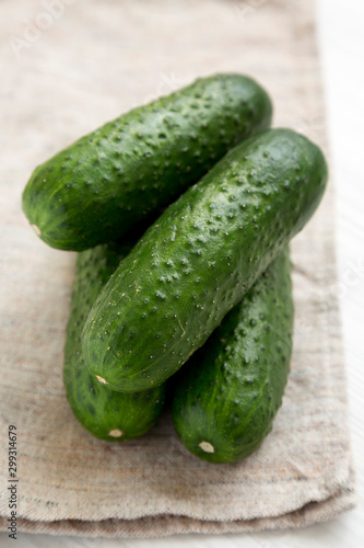 Fresh mini baby cucumbers on a rustic wooden board, low angle view. Close-up.