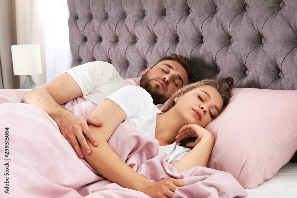 Young couple sleeping together in bed at home Young couple sleeping together in bed at home
