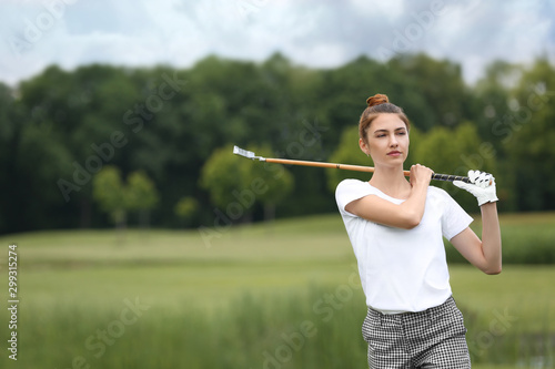 Woman playing golf on green course. Sport and leisure