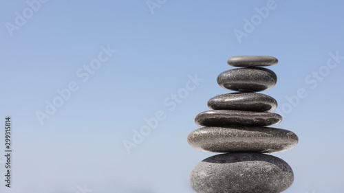Stack of stones against blue sky  space for text. Zen concept