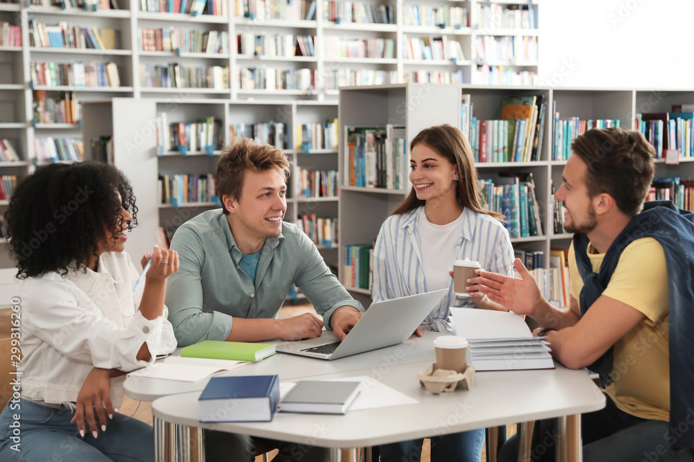 Group of young people studying at table in library Group of young people studying at table in library