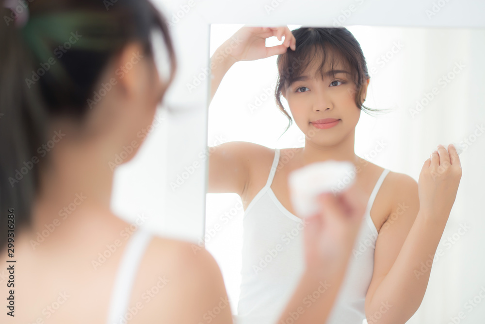 Beautiful young asian woman smiling with skin care cosmetic use oil blotting paper on face looking mirror at room, beauty asia girl wipe and cleansing makeup with tissue, clean on facial concept. Beautiful young asian woman smiling with skin care cosmetic use oil blotting paper on face looking mirror at room, beauty asia girl wipe and cleansing makeup with tissue, clean on facial concept.