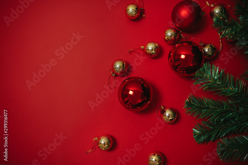 Christmas ornaments on the red background. Christmas decorations with space for text. Red and golden christmas balls and green christmas tree. Greeting card. © Маргарита Щипкова