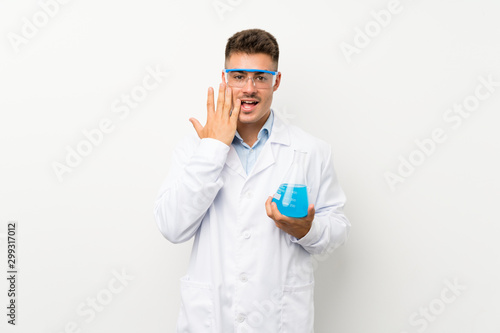 Young scientific holding laboratory flask over isolated background with surprise facial expression