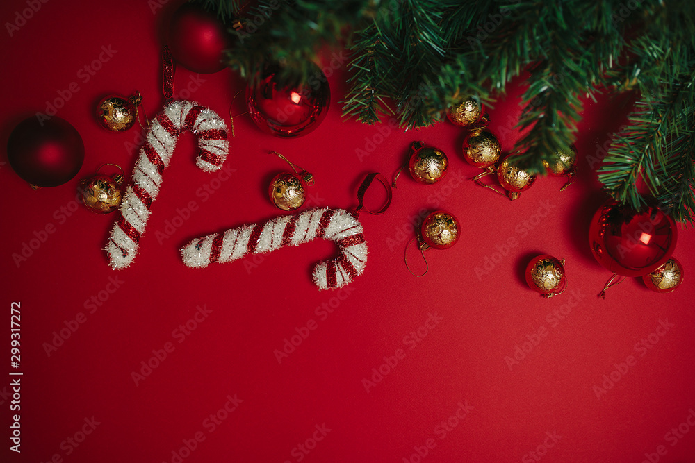 Christmas ornaments on the red background. Christmas decorations with space for text. Candy canes and balls. Christmas card.