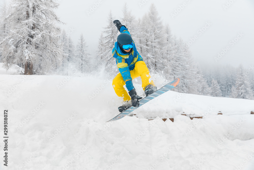 Man with snowboard jumping and doing tricks on the snow