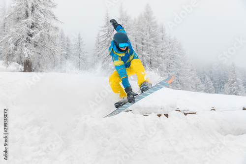 Man with snowboard jumping and doing tricks on the snow