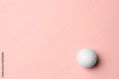 Golf ball on pink background, top view. Space for text