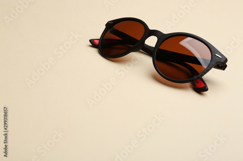 Stylish sunglasses on beige background, space for text. Fashionable accessory