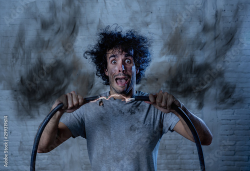 Cuadro en lienzo Funny image of man getting electric shock with funny face and smoke all around