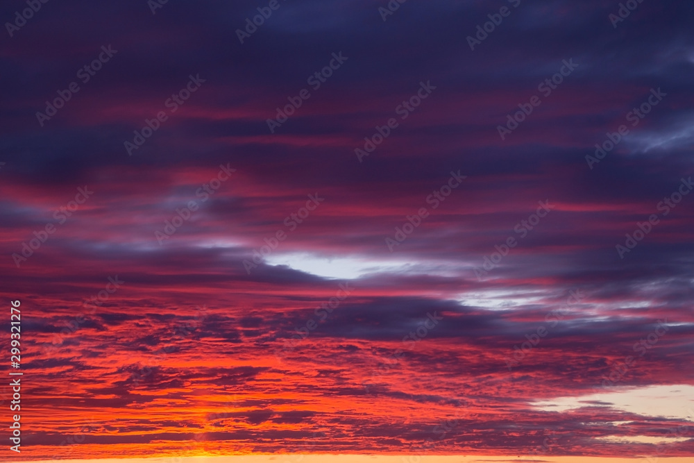 Beautiful epic dramatic sunset orange pink blue sky with clouds background texture
