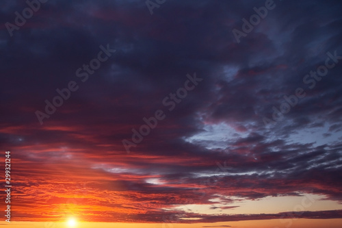 Epic dramatic sunset, sunrise orange sky with clouds, sun and sunlight 