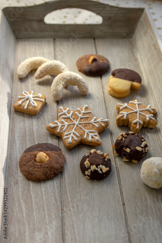 Group various kinds of delicious sweet Christmas cookies on light gray wood, tasty holiday breakfast photo