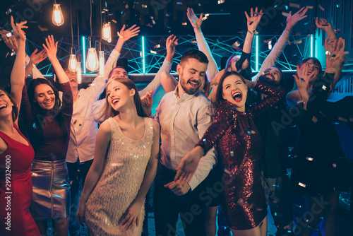 Photo of dancing people dressed in formalwear rejoicing good free time together with macho surrounded by girls hanging out between them in falling confetti