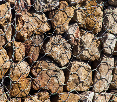 Stones in a metal grid as an abstract background © schankz