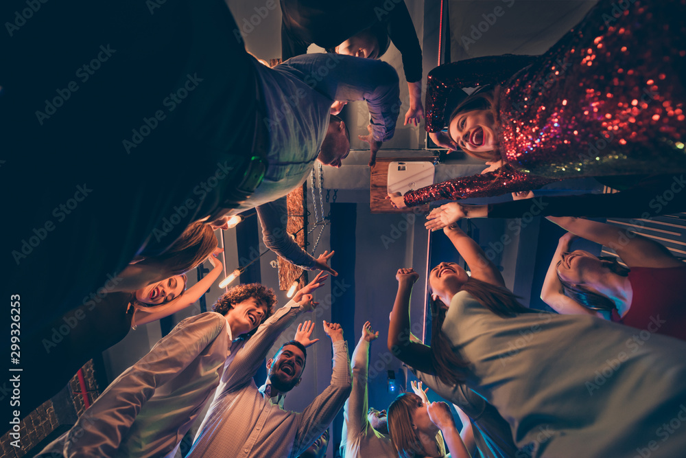 Low angle view photo of cheerful positive wild group people stand around having fun on party dance feel rejoice crazy raise hands wear formalwear dress shirt on discotheque