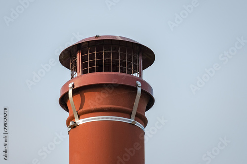 Принти на полотні Isolated view of an old fashioned, terracotta chimney pot seen on a cottage roof, against a clear sky