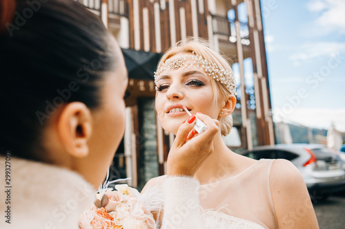 Amazing makeup artist paints the lips of a beautiful bride