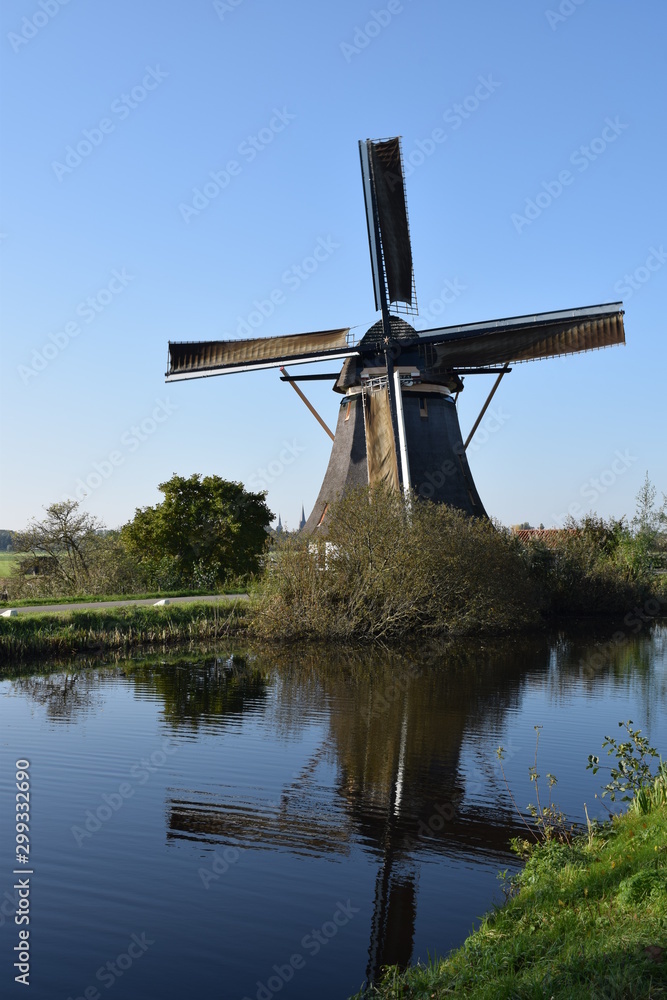 Dutch wind mill located near amsterdam reflected in water 