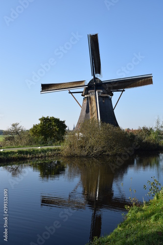Dutch wind mill located near amsterdam reflected in water 