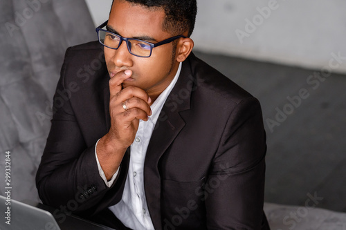 Top view of a successful serious young african american journalist in formal clothes working on a new article while sitting at home with a laptop. Journalism and blogging concept