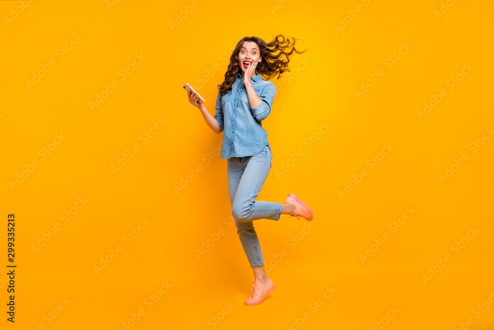 Full length body size photo of cheerful crazy sweet pretty girlish feminine youngster overjoyed about having received long expected message holding phone expressing emotions isolated vivid color