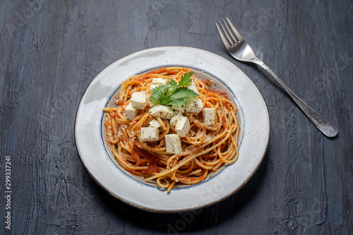 Spaghetti pasta with fresh and parmesan cheese on dark background