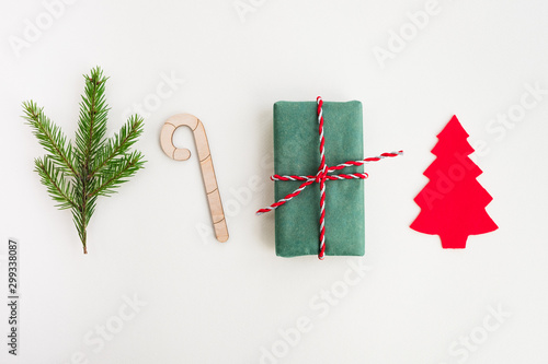 Christmas and New Year composition. Gift box, fir branch and festive decor on a light beige pastel background. Top view, flat lay