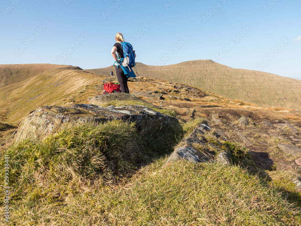 A woman hiking in the mountains of the Brecon Beacons National Park, Wales.