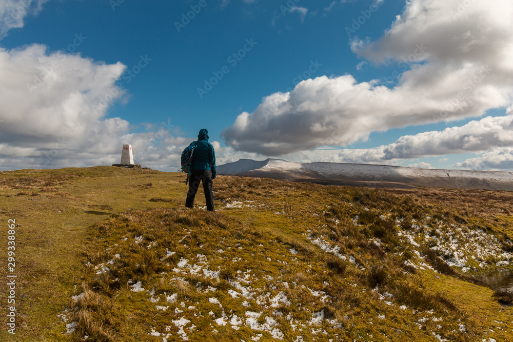 Woman hiking in mountains in the Brecon Beacons National Park, Wales, in winter.