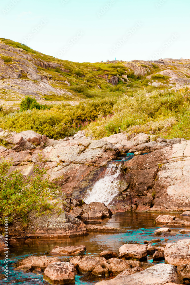 Beautiful summer day landscape waterfall North Teriberka, Barents sea view.