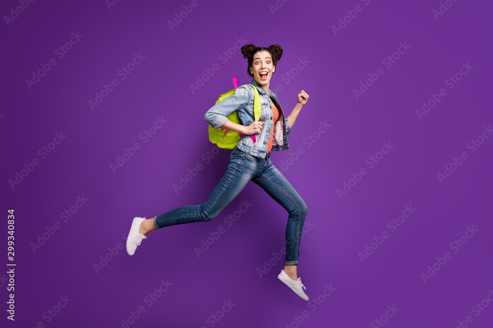 Full body profile photo of funny student lady jumping high rushing home after last studying day wear green bag casual denim outfit isolated purple color background