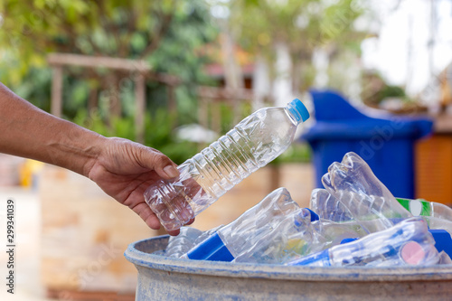 Wallpaper Mural Hand holding recyclable plastic bottle in garbage bin for cleaning. Torontodigital.ca
