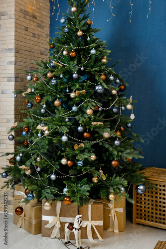 Modern design Christmas tree decorated with balls and garlands - navy blue, brown, beige. Winter holidays composition. Close up