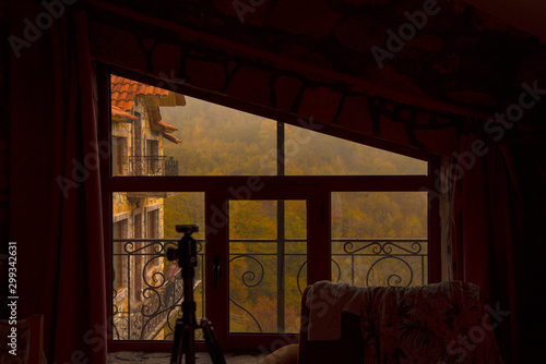 Through the window you can see the autumn forest and part of the neighboring house.