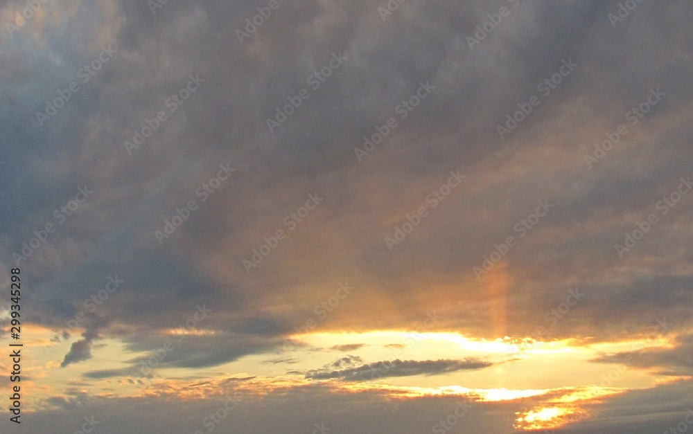 sky with clouds and sunrays at sunset
