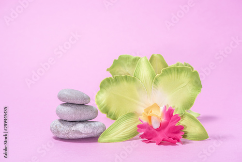 White soft terry towels  orchid  stones and candles for skin care and spa on a pink background