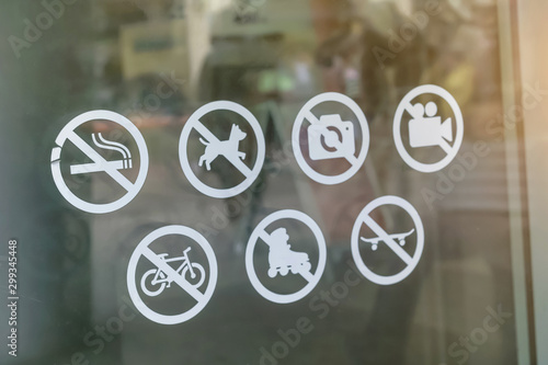 stickers with ban of rollers, bicycle, smoking, photo, video, camera, pets, dog on door of entrance to shopping center photo