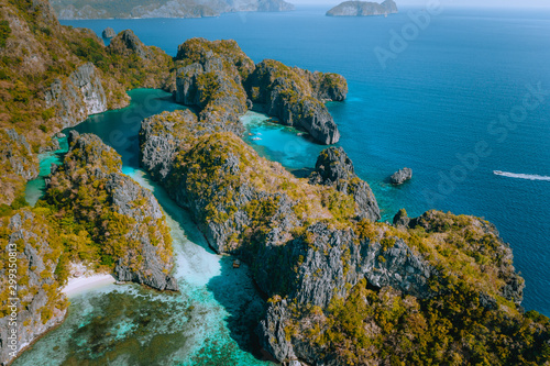 Aerial drone view of a beautiful tropical blue lagoon surrounded by jagged limestone cliffs. Miniloc Island, El Nido, Palawan, Philippines