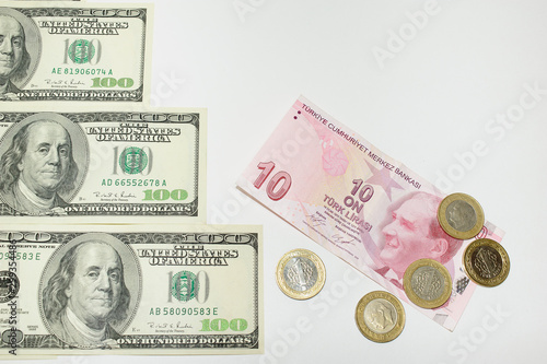 steps of one hundred American dollar bills on which rises a banknote of ten Turkish Lira and Turkish coins Kurush